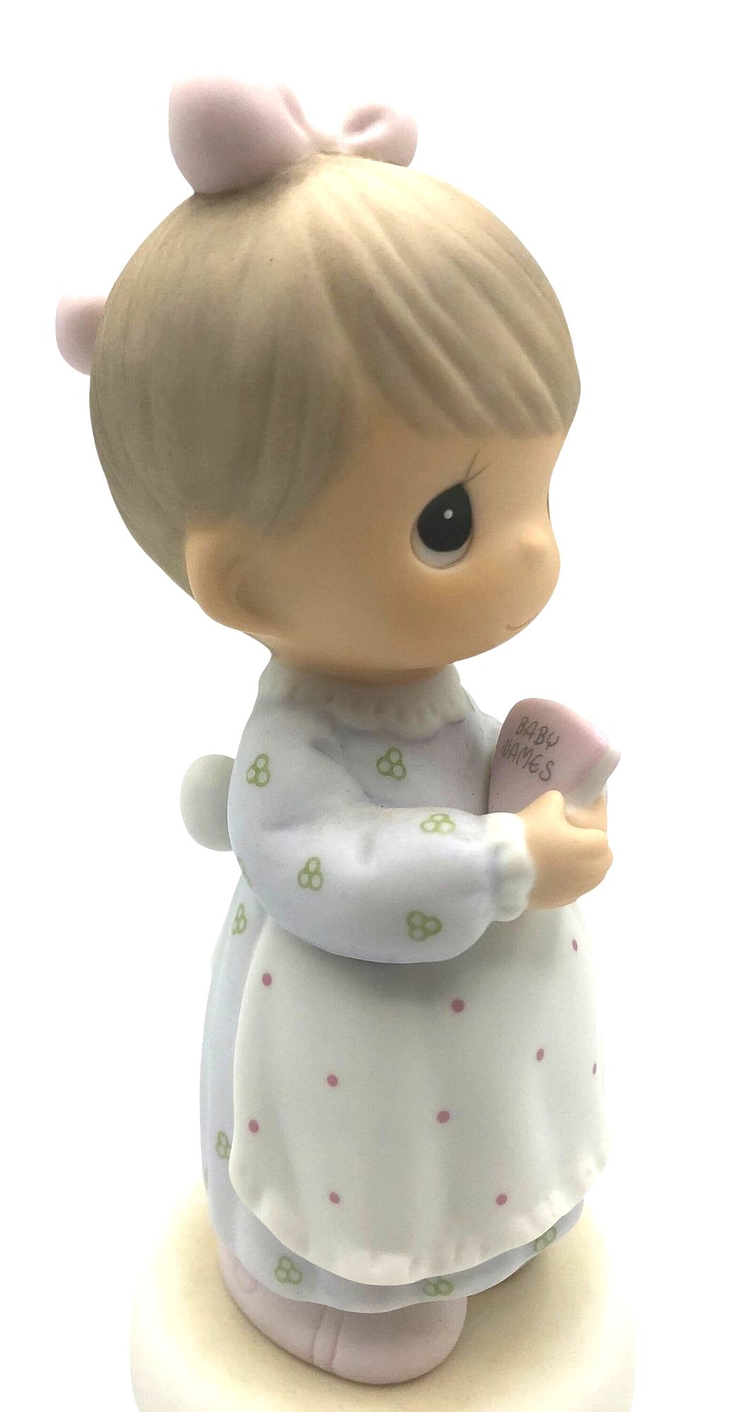 Precious Moments "The Good Lord Always Delivers" Porcelain Figurine. Features a little expectant mom perusing a book of baby names.