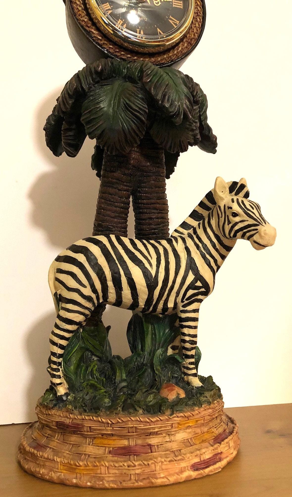 Zebra Clock Sculptured in the Grass with Palm Trees.  5" x 6" x 15" high. Clock works with AA battery, not included.  Excellent Condition