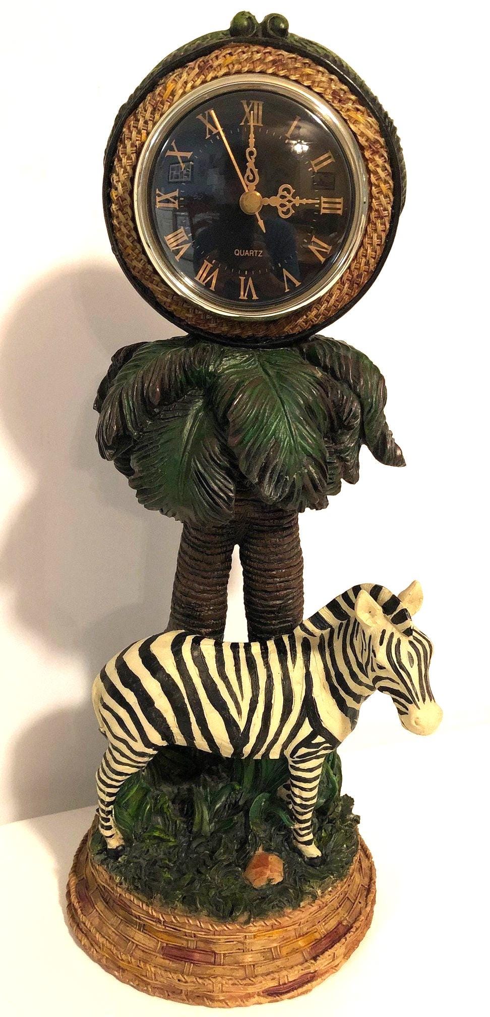 Zebra Clock Sculptured in the Grass with Palm Trees.  5" x 6" x 15" high. Clock works with AA battery, not included.  Excellent Condition