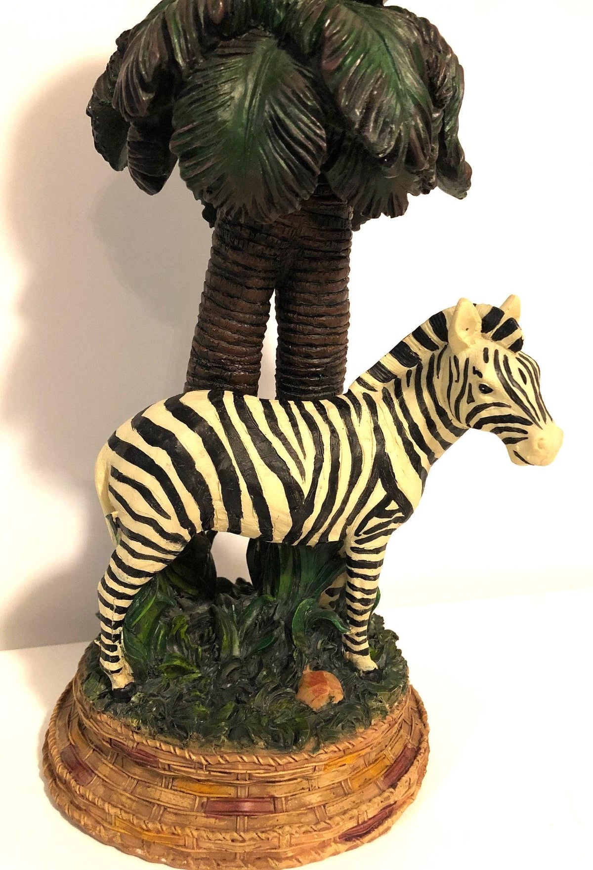 Zebra Clock Sculptured in the Grass with Palm Trees.  5" x 6" x 15" high. Clock works with AA battery, not included.  Excellent Condition