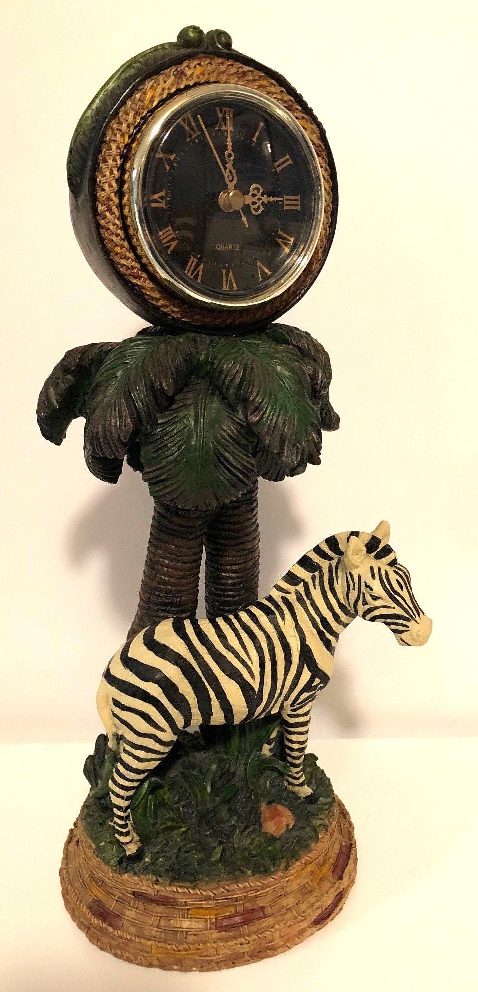 Zebra Clock Sculptured in the Grass with Palm Trees.  5" x 6" x 15" high. Clock works with AA battery, not included.  Excellent Condition