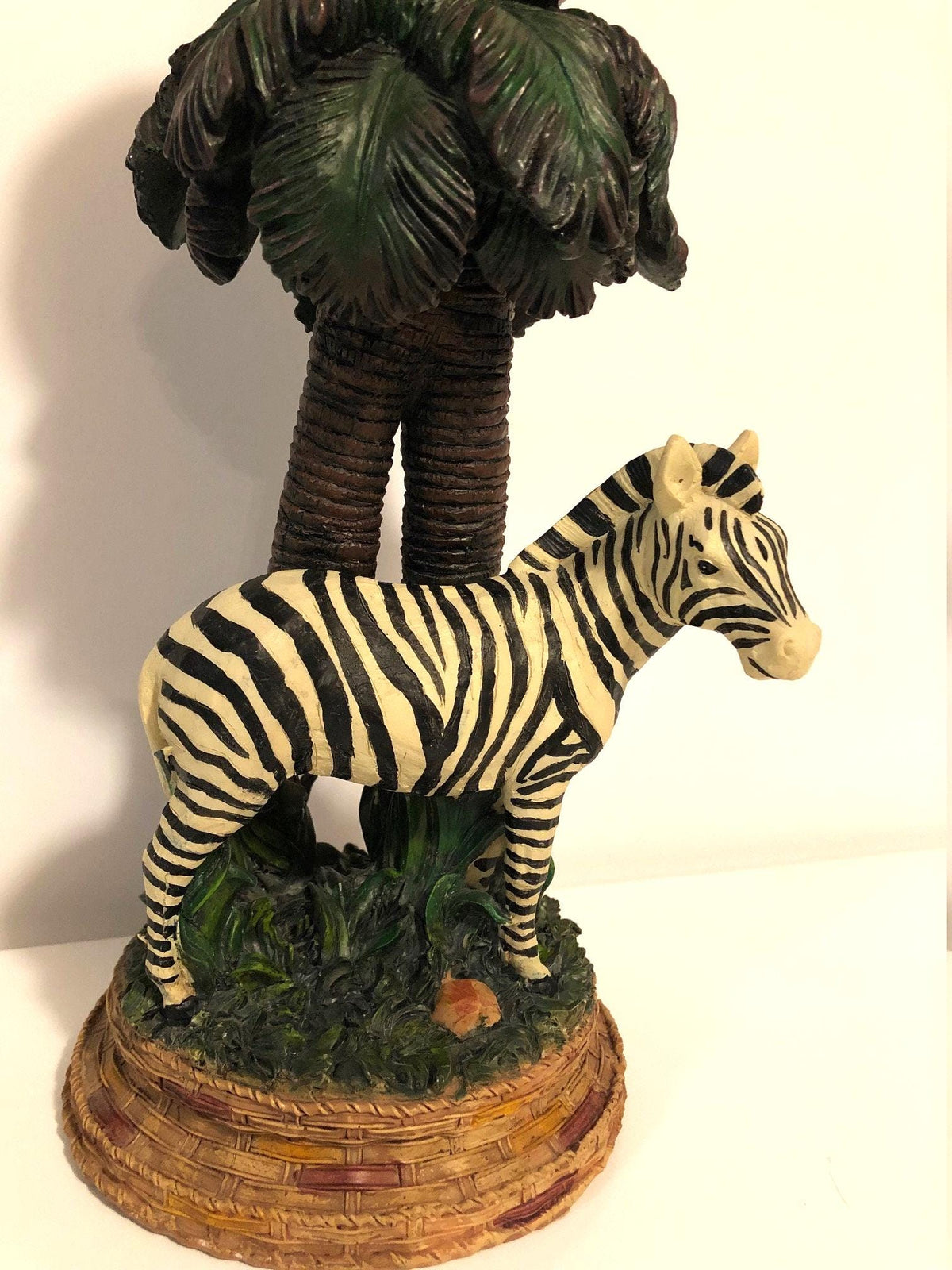 Zebra Clock Sculptured in the Grass with Palm Trees.  5" x 6" x 15" high. Clock works with AA battery, not included.  Excellent Condition
